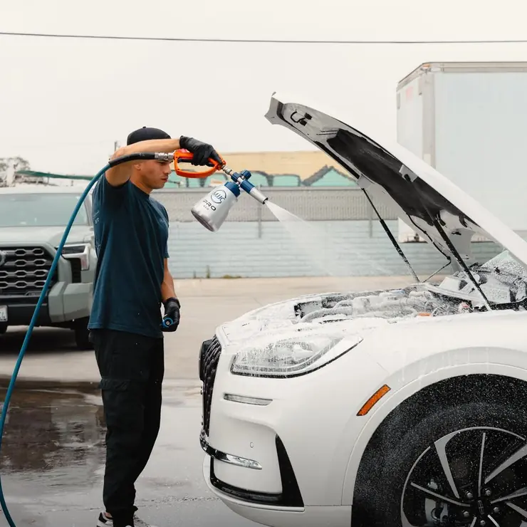 Foam-washing the front of an SUV during a mobile detail
