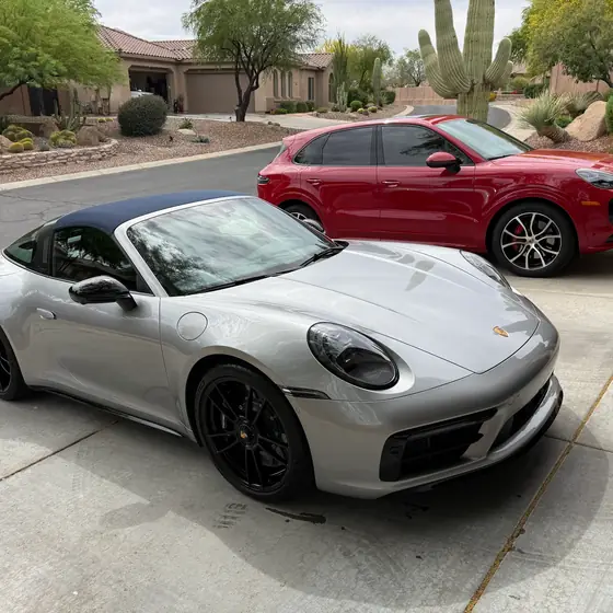 Silver Porsche 911 Targa and red Porsche Cayenne in a driveway after a mobile exterior detail