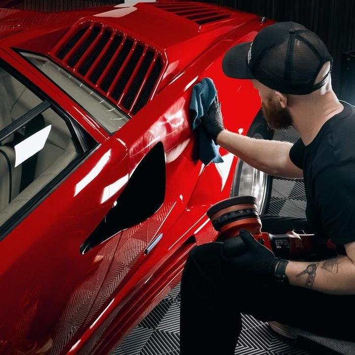 Machine polishing restoring deep gloss to red paint