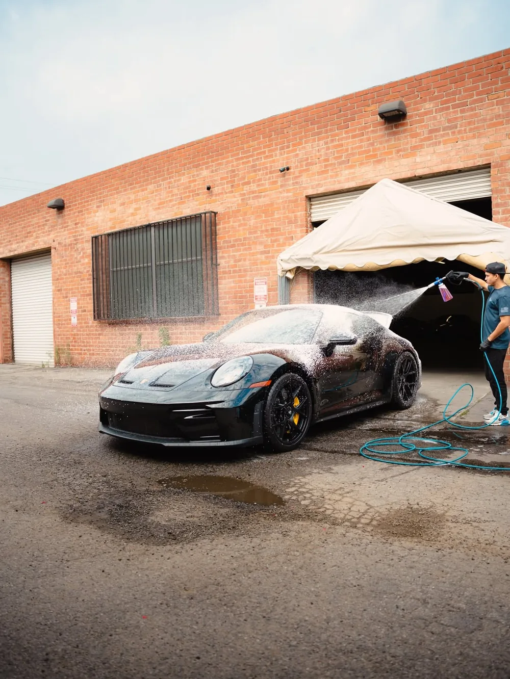 Marrufo detailer foam-washing a black Porsche during a mobile detail