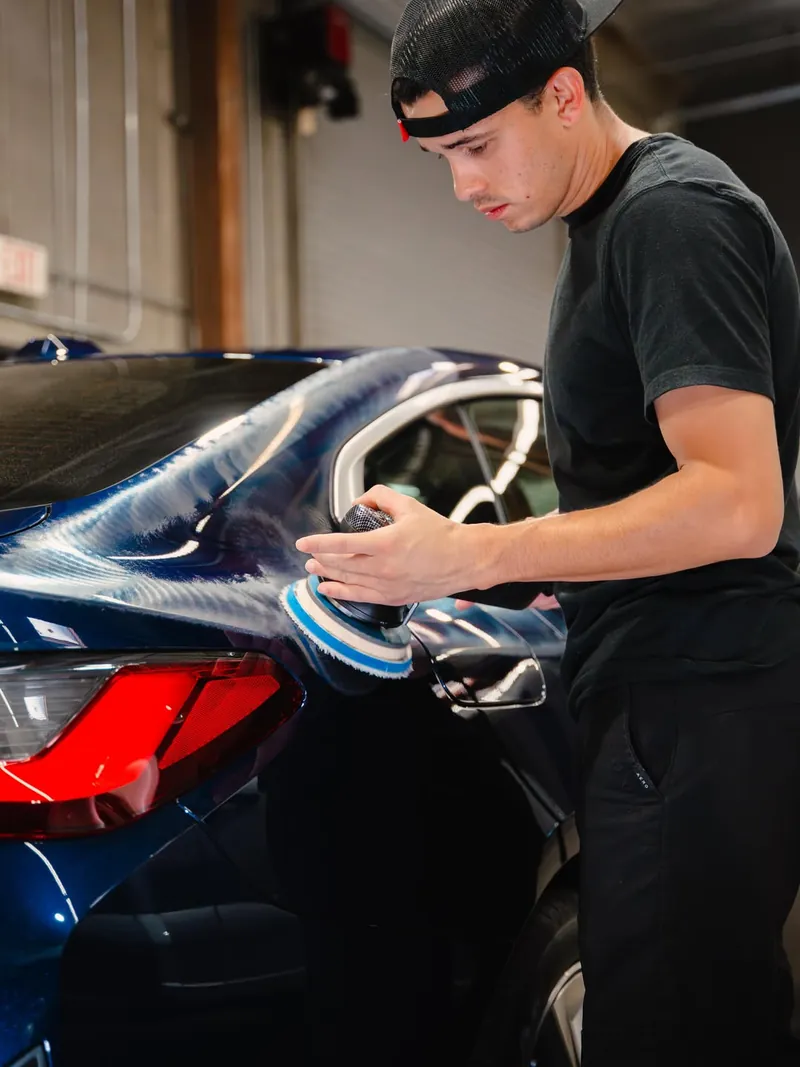Polishing a blue BMW rear quarter before coating