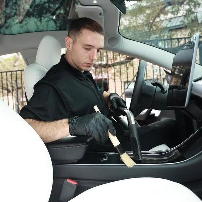 Detailer deep-cleaning a vehicle interior on location
