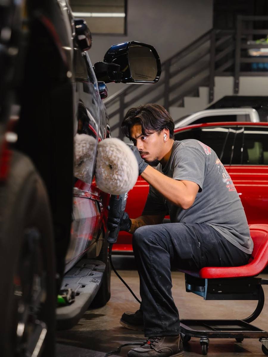 Detailer machine-polishing a panel