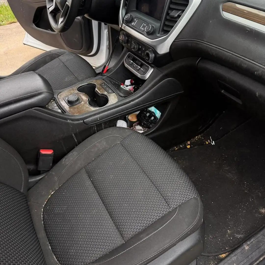 GMC Acadia front seats and console before the detail, dirt and debris on the seat and floor