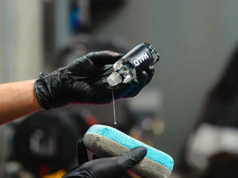 Coating being poured onto an applicator with gloved hands