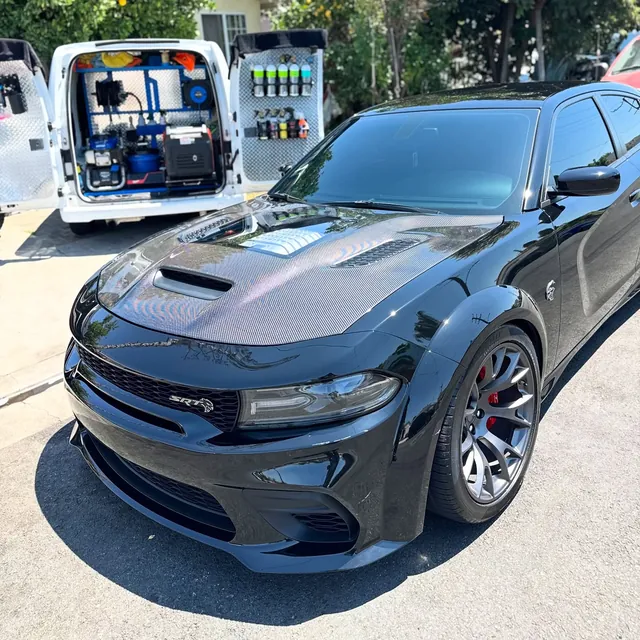 Our van with the back doors open next to a black Charger we just detailed