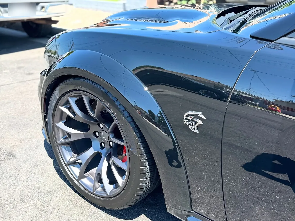 Black Dodge Charger fender with sharp reflections after polishing