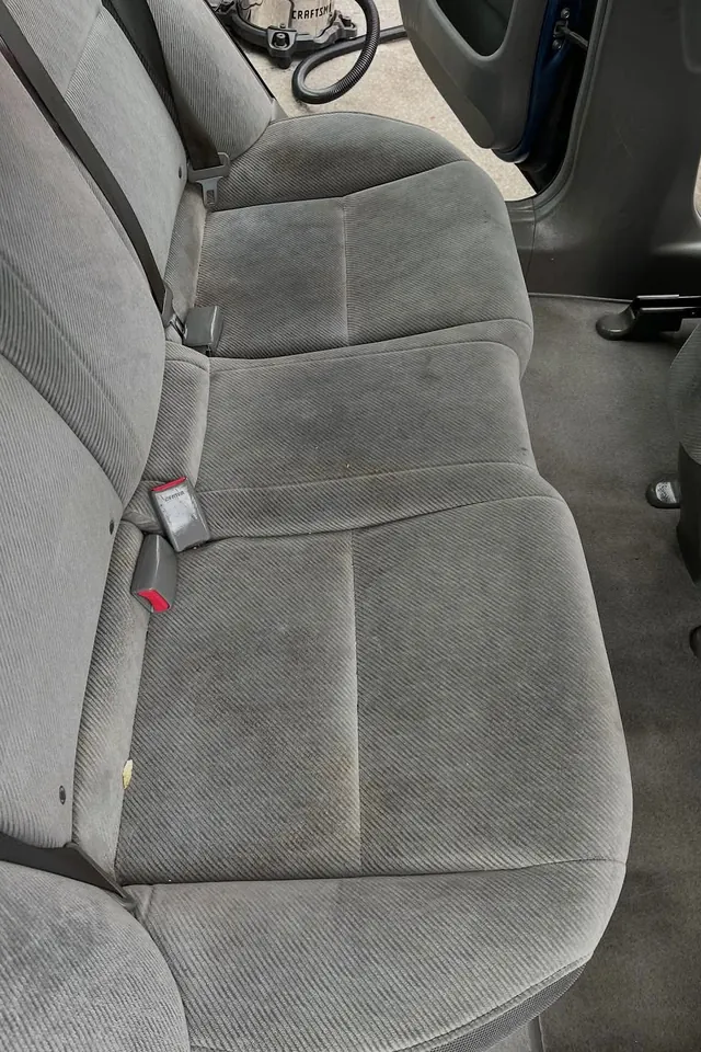 Gray cloth back seat before, dirty and spotted