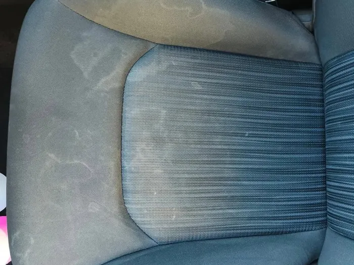 Cloth driver seat before, covered in water stains