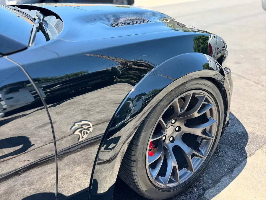 Black Dodge Charger fender with clear reflections after polishing