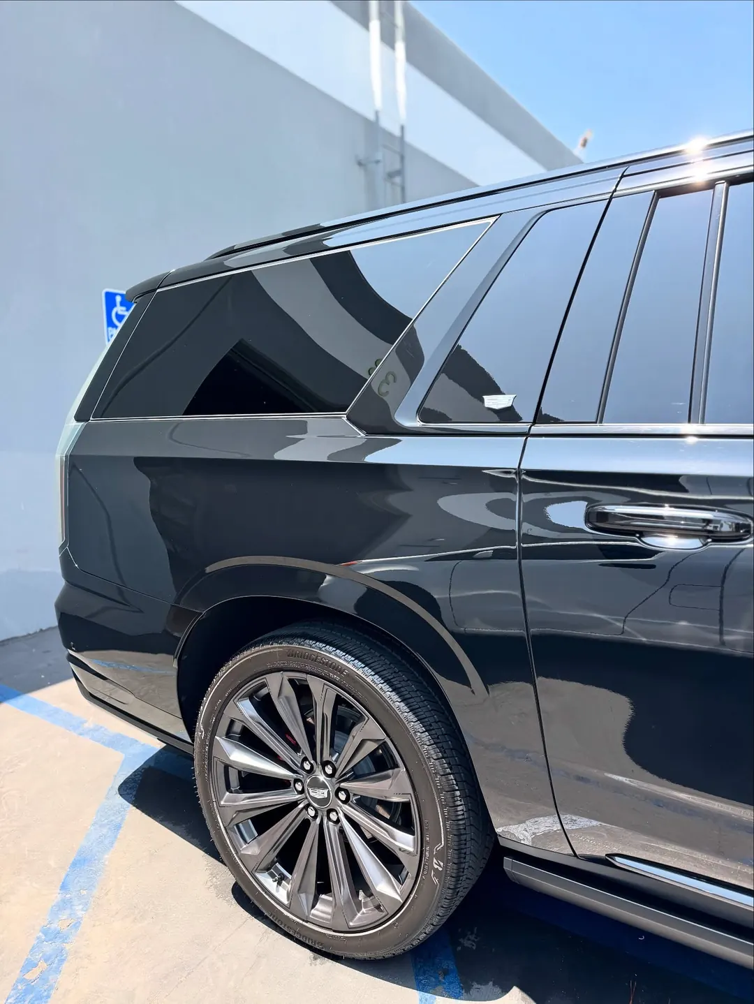 Side of a black Cadillac Escalade with deep gloss and clean wheels